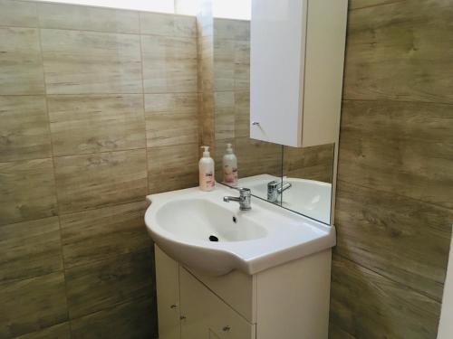 a bathroom with a sink and a mirror at Hanna Apartman in Balatonlelle