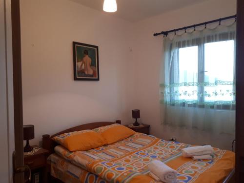 - une chambre avec un lit doté d'oreillers orange et une fenêtre dans l'établissement Apartments Darija, à Žabljak