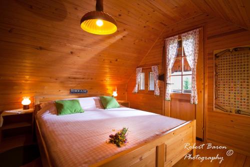 Un dormitorio con una cama en una cabaña de madera. en Domačija Koklej - Apartments Vintage Vacation, en Luče