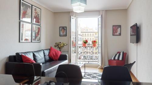 sala de estar con sofá y mesa de cristal en Apartamento Plaza Del Castillo, en Pamplona