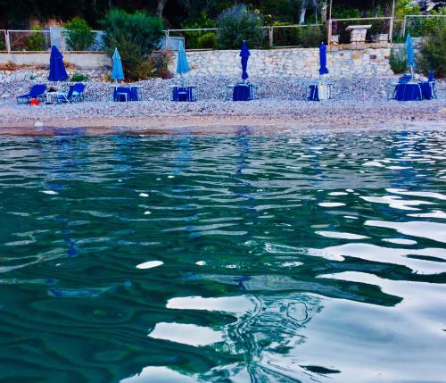 a body of water with chairs and a beach at Villa Sofia in Chrani