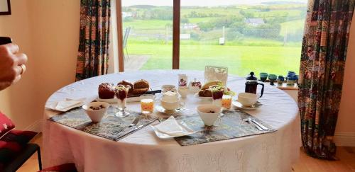 a table with a white table cloth with pastries on it at Western Greenway B&B in Newport