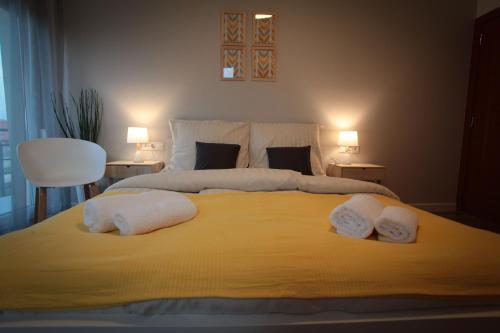 a bedroom with a bed with two towels on it at Airport Almáskert Panzió in Vecsés
