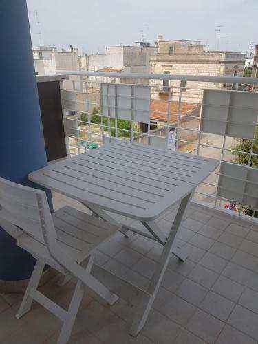 a white picnic table on a balcony with a view at "La casa di Mariagrazia" Appartamento 4 locali in Sammichele di Bari