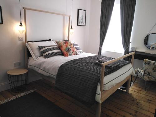 um quarto com uma cama grande e uma janela em Aubrey Cottage em Cowbridge