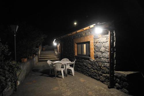 a table and chairs next to a building at night at Etna Paradise locazioni brevi in Ragalna