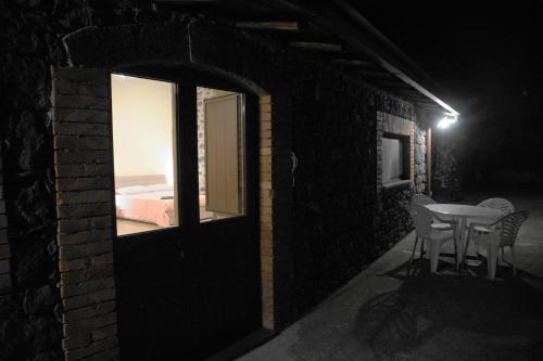 a small room with a table and chairs at night at Etna Paradise locazioni brevi in Ragalna