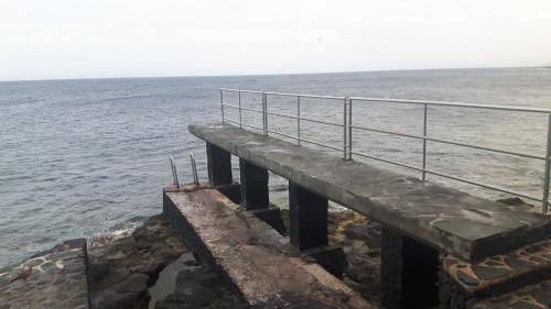 a wooden pier sticking out into the ocean at Apartamento La Caleta El Hierro Island terrace with incredible views in La Caleta