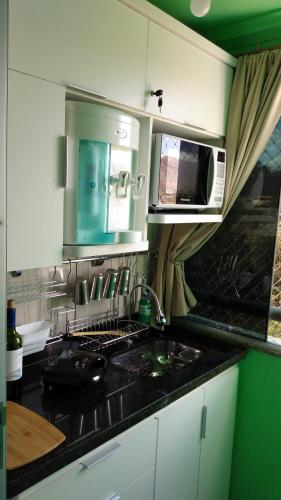 a kitchen with a sink and a microwave at FLAT 609-B Rio Quente in Rio Quente