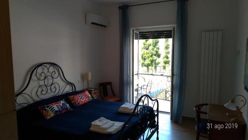 sypialnia z łóżkiem i drzwiami prowadzącymi na balkon w obiekcie Casa di Rosita w Rzymie