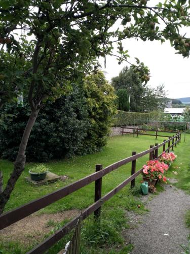 une clôture en bois avec des fleurs sur un champ dans l'établissement Mortlach Cottage, à Dufftown