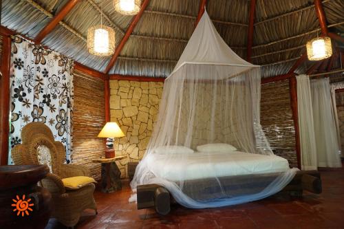 a bedroom with a bed with a mosquito net at Locanda Samara Beach in Sámara