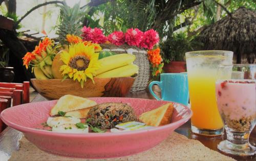 a table with a bowl of food and a glass of orange juice at Locanda Samara Beach in Sámara