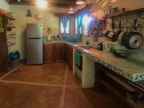 a kitchen with a refrigerator and a counter top at Casita de los Sueños in Cabuya