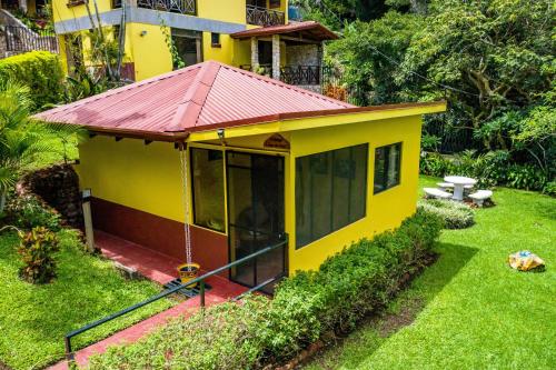 a small yellow house with a red roof at La Terraza Guest House B&B in Grecia