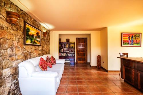 a living room with a white couch and a stone wall at La Terraza Guest House B&B in Grecia