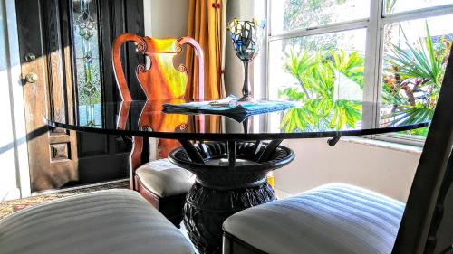 uma mesa de vidro num quarto com duas cadeiras e uma janela em Boca Ciega Bay Apartment em St. Pete Beach
