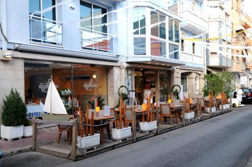 um restaurante com mesas e cadeiras em frente a um edifício em Hostal Can Marinés em Sant Carles de la Ràpita