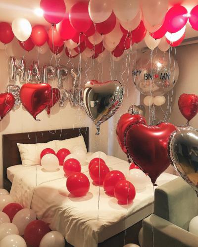 a bed with hearts and balloons in a room at An Nguyen Building in Hanoi