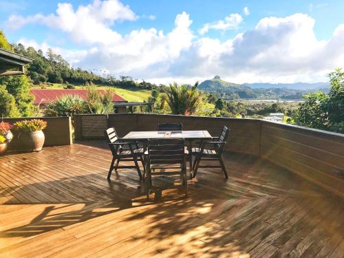 un patio con mesa y sillas en una terraza de madera en Coastal Chalet Suites Whangaroa, en Kaeo