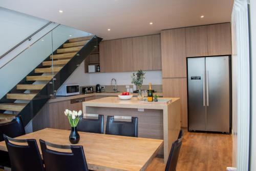 a kitchen and dining room with a table and a staircase at Kabuki Mt Buller in Mount Buller