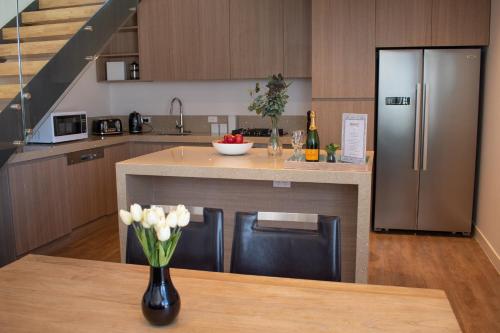 a kitchen with a refrigerator and a table with a vase of flowers at Kabuki Mt Buller in Mount Buller
