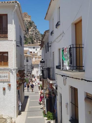 an alley with buildings and people walking down a street at Residential jardín del pintor - la casa amarilla in Jacarilla