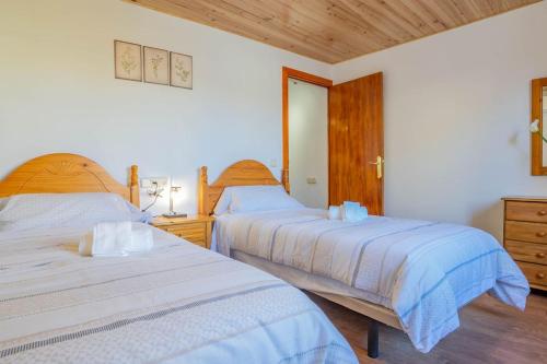 two beds in a bedroom with wooden floors at Casa López in Alcudia