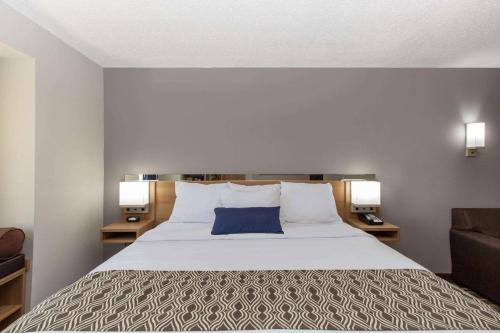 a bedroom with a large bed with a blue pillow at Microtel Inn & Suites by Wyndham Augusta/Riverwatch in Augusta