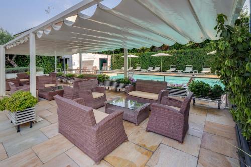 a patio with wicker furniture and a swimming pool at Jet Hotel, Sure Hotel Collection by Best Western in Gallarate
