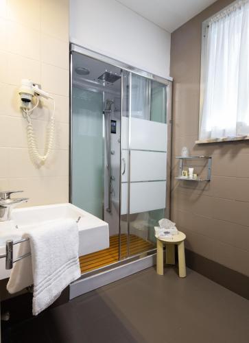 a bathroom with a shower and a tub and a sink at Jet Hotel, Sure Hotel Collection by Best Western in Gallarate