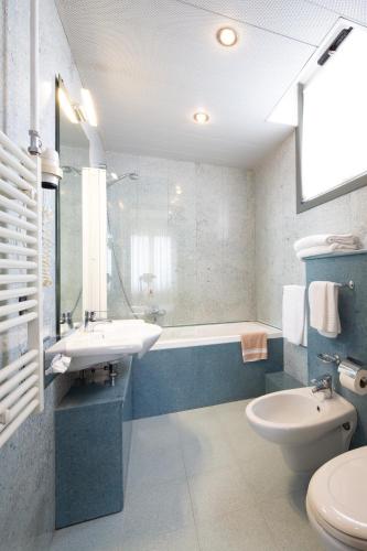a bathroom with a sink and a tub and a toilet at Jet Hotel, Sure Hotel Collection by Best Western in Gallarate
