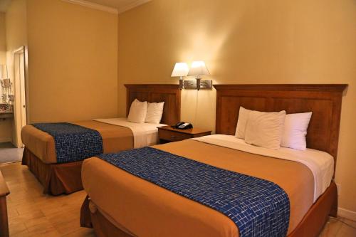 a hotel room with two beds in a room at Travelodge by Wyndham Pasadena Central in Pasadena