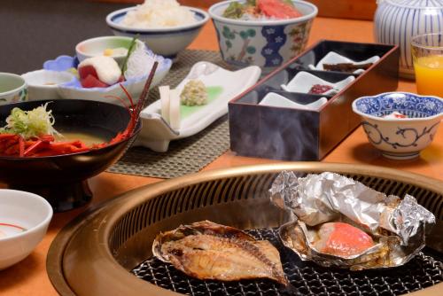 Una mesa con un plato de comida y tazones de comida. en Senoumi, en Higashiizu