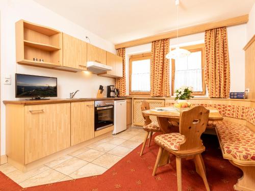 eine Küche und ein Esszimmer mit einem Tisch und Stühlen in der Unterkunft Tramberger Apartments in Reith im Alpbachtal