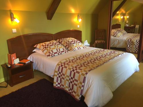 a hotel room with a large bed and a mirror at Auberge Du Cheval Blanc - Teritoria in Selles-Saint-Denis