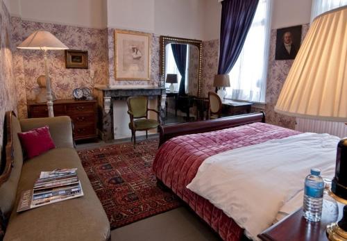 a bedroom with a bed and a couch and a table at B&B The Baron in Antwerp