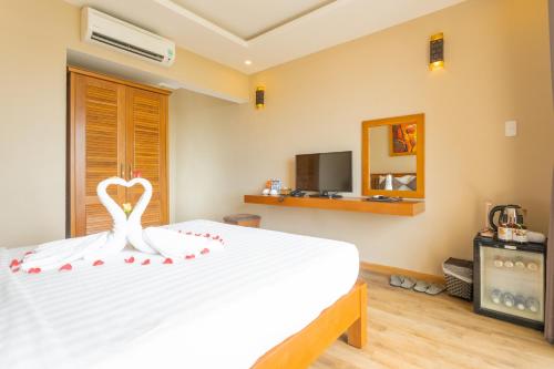 a bedroom with a white bed with a heart on it at Jazz Hotel in Danang