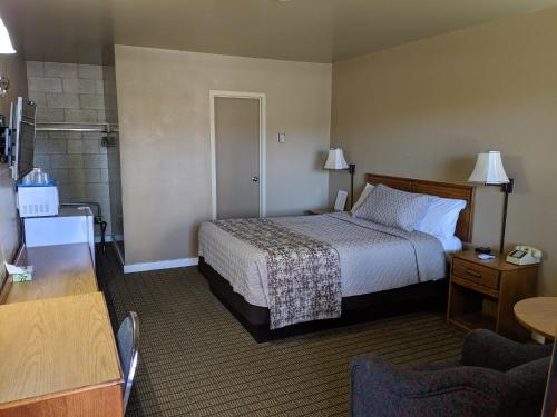 a hotel room with a bed and a bathroom at Economy Inn Elko in Elko