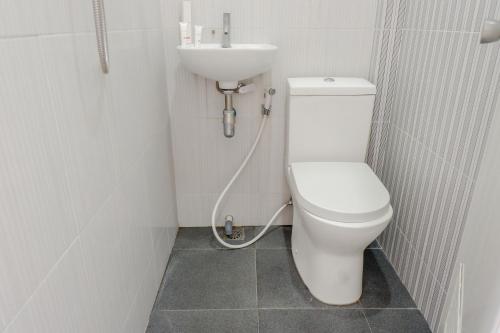 La salle de bains est pourvue de toilettes blanches et d'un lavabo. dans l'établissement Super OYO Capital O 1176 J3 Residence Syariah, à Jember