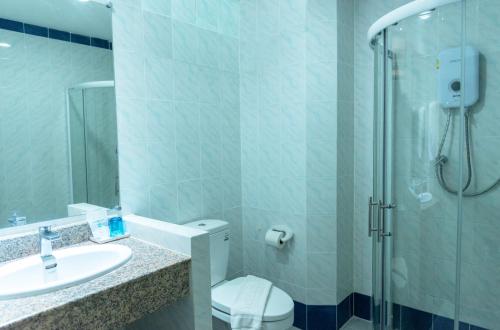 a bathroom with a shower and a toilet and a sink at Park 38 Hotel - SHA Plus in Phuket Town