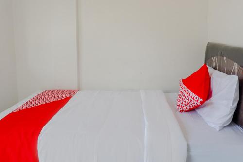 a bed with red and white pillows on it at Capital O 1176 J3 Residence Syariah in Jember