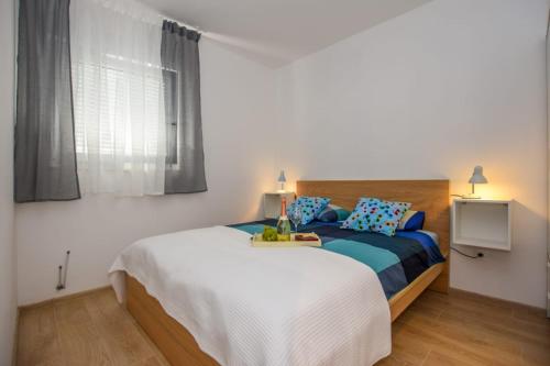 a bedroom with a bed and a window at Apartments Milena 8 in Mandre