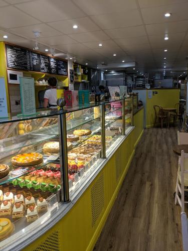 a bakery with a display case filled with lots of pastries at Modern 2 Bedroom Flat with private outdoor terrace in London