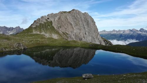 a mountain reflecting in a lake in the mountains at Haus Heiserer in Musau