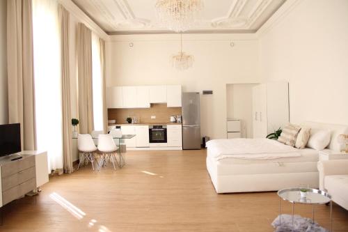 a white living room with a white couch and a kitchen at Luxury Design City centre Apartment in Brno