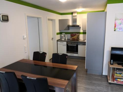 een keuken met een tafel en stoelen in een kamer bij Ferienwohnung Pfaffenberg in Oberteuringen