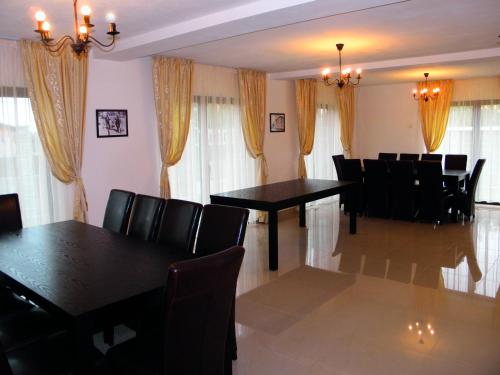 uma sala de jantar com mesas e cadeiras pretas em Pensiunea Platinum em Târgu Jiu