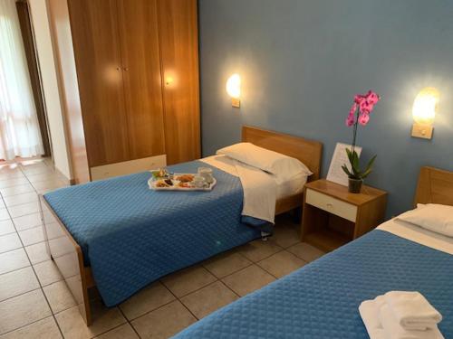 a hotel room with two beds and a tray of food on a table at Albergo Papillon in San Polo dʼEnza in Caviano