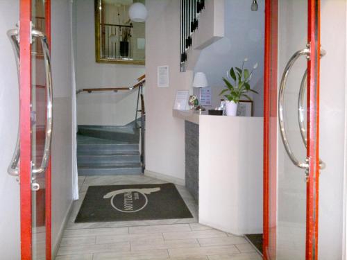 a hallway with a staircase with a rug on the floor at Albergo Papillon in San Polo dʼEnza in Caviano